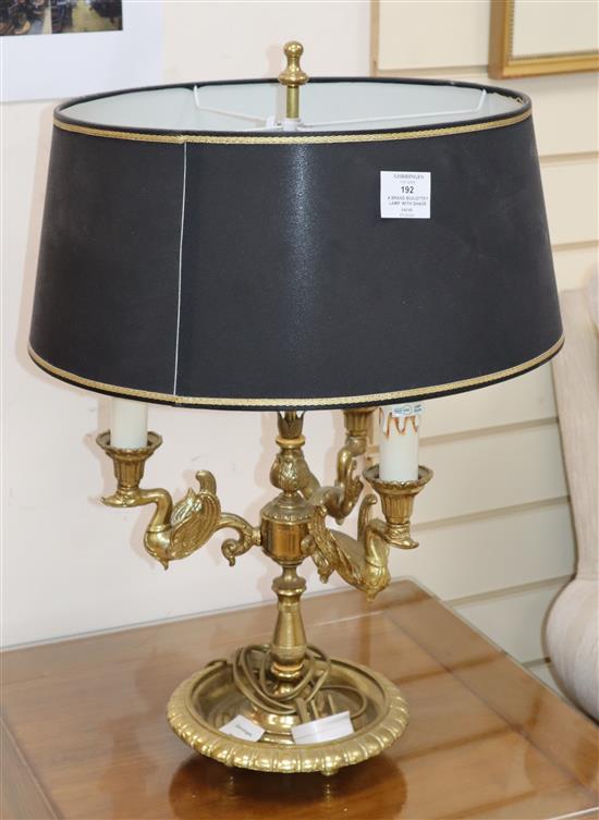 A brass lamp, with black and gold shade